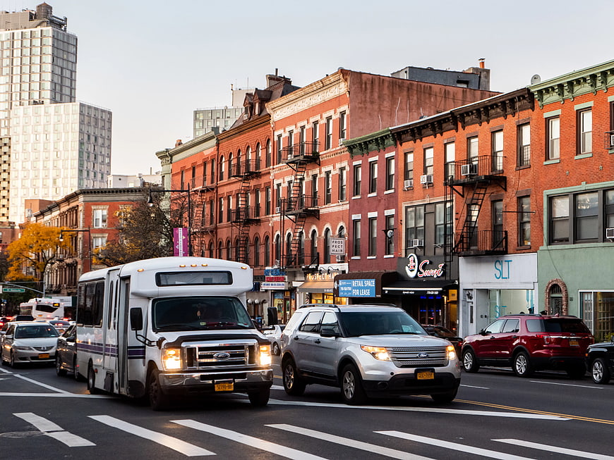 Shuttle Bus and Cars on Brooklyn Street with Brick Buildings