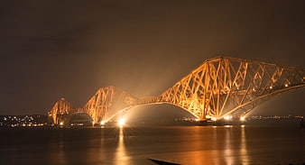 Illuminated Forth Bridge at Night with Golden Lights