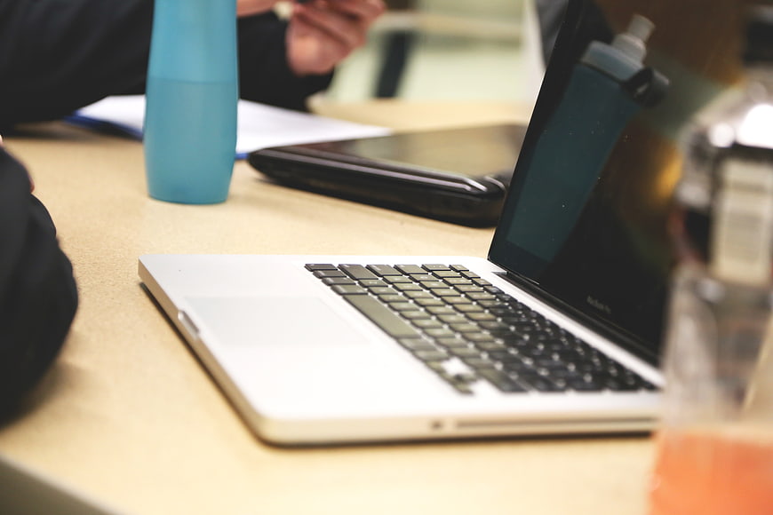 Close-up of laptop on office desk with water bottle