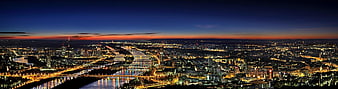 Panoramic Vienna cityscape at twilight with Danube river lights