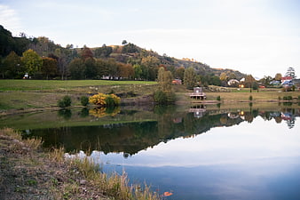 Serene Autumn Lake Landscape with Reflections and Rolling Hills