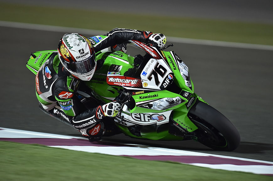 Green Kawasaki MotoGP Rider Leaning into Turn on Track