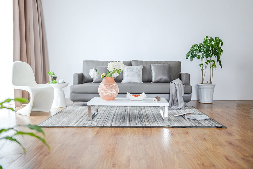 Modern minimalist living room with gray sofa and white decor