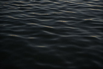 Dark rippling water surface with subtle golden reflections