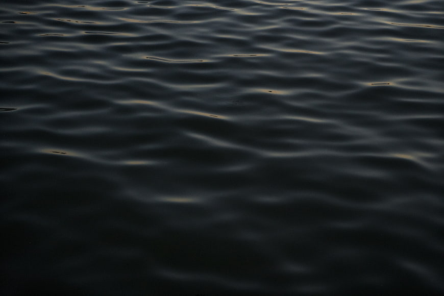 Dark rippling water surface with subtle golden reflections