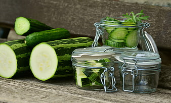 Fresh Zucchini and Pickles in Glass Jars on Rustic Wood