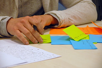 Hands organizing colorful sticky notes for brainstorming session