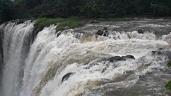 Powerful waterfall cascading over rocky river rapids