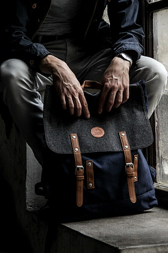 Man Sitting with Dark Canvas Backpack on Urban Steps
