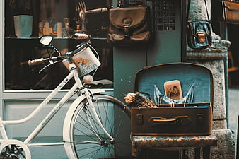 Vintage bicycle and open suitcase with photo on street