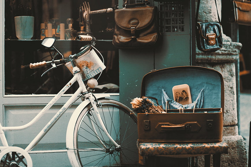 Vintage bicycle and open suitcase with photo on street