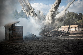Dramatic war reenactment with explosions and soldiers in trenches
