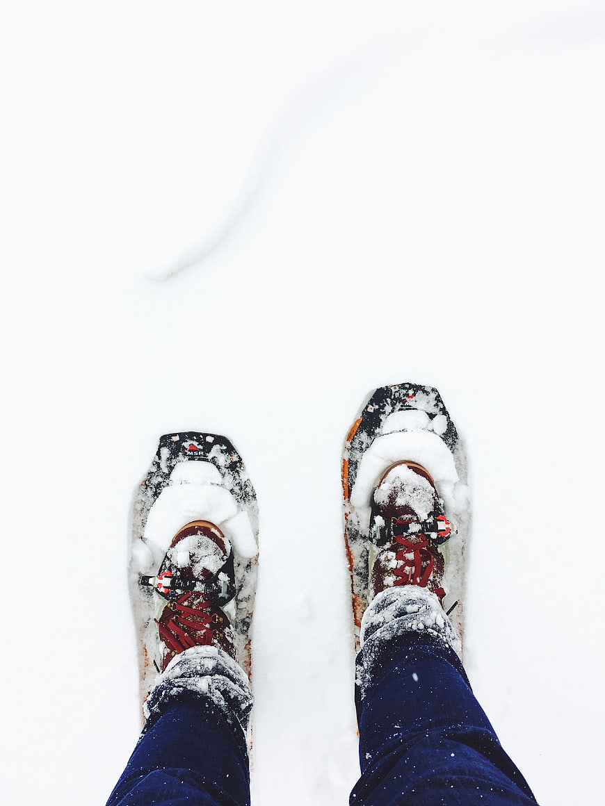 First-person view of snowshoes in deep white snow