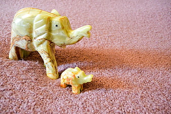 Carved Onyx Elephant Figurines on Textured Pink Surface