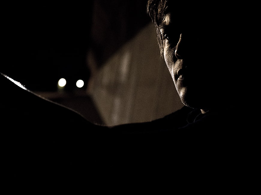 Dramatic low-key portrait of a man in shadow