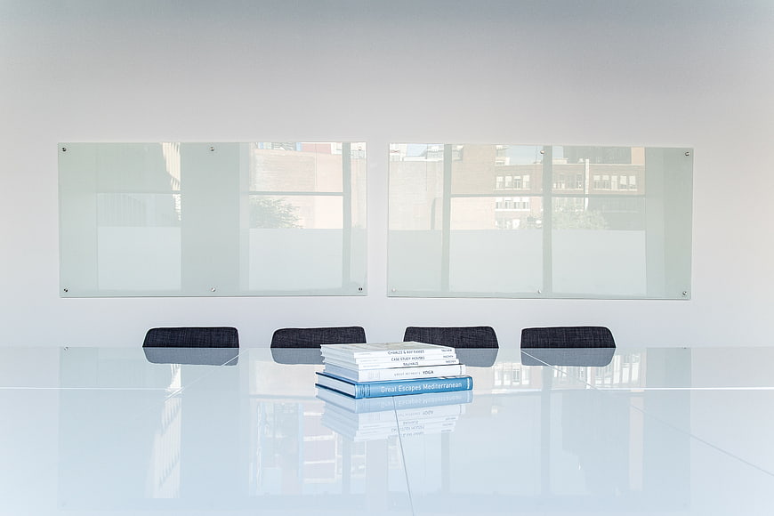Minimalist modern office meeting room with glass table and books