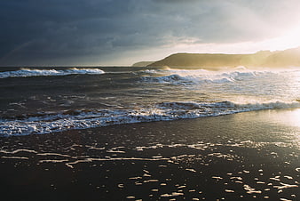 Dramatic Sunset Ocean Waves on Dark Sandy Beach