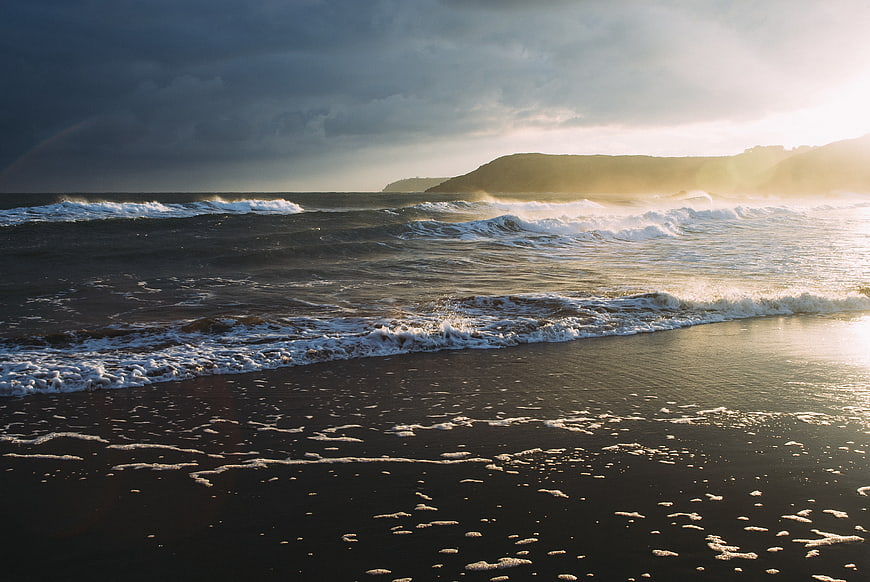 Dramatic Sunset Ocean Waves on Dark Sandy Beach