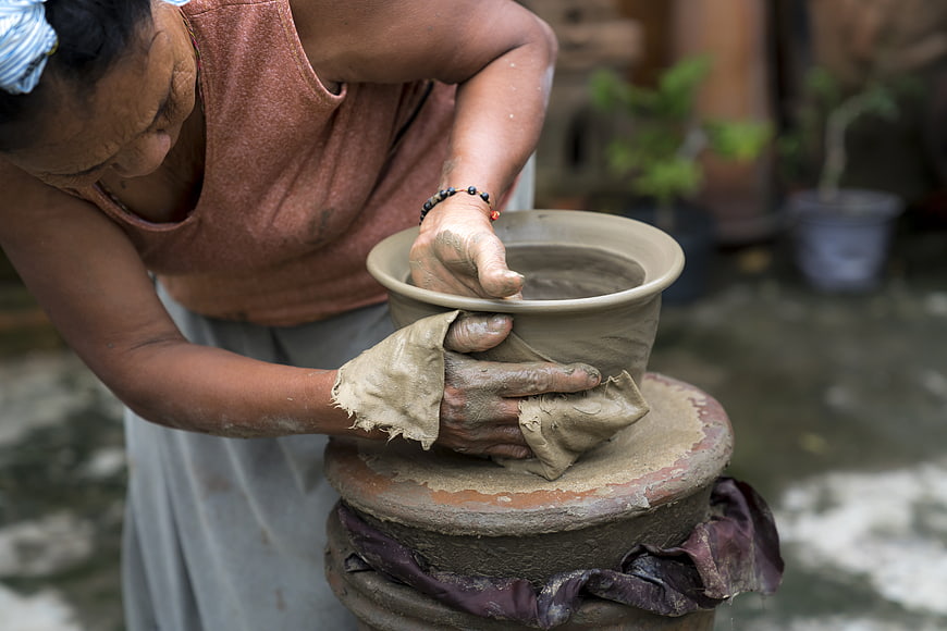 Senior Woman Shaping Clay Pottery on Traditional Wheel