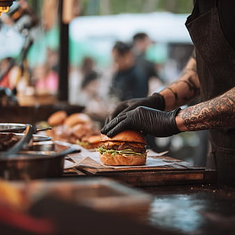 Chef Assembling Gourmet Burger at Street Food Stall