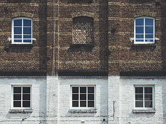 Symmetrical brick building facade with white painted lower section