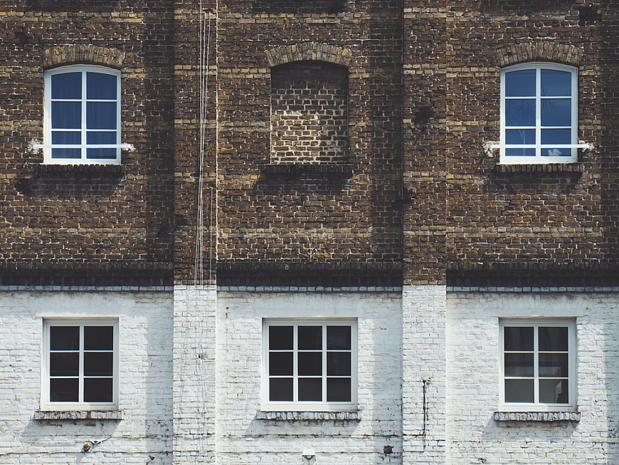Symmetrical brick building facade with white painted lower section