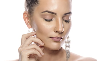 Close-up portrait of a woman with clean skin and elegant silver earrings