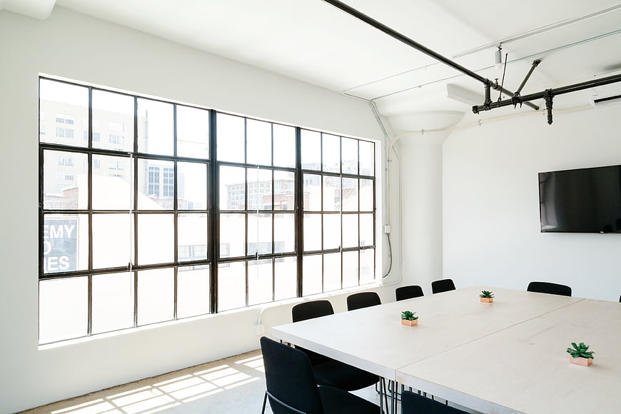 Modern minimalist office meeting room with large industrial windows