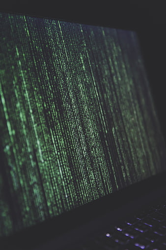 Close-up of laptop screen displaying green Matrix-style code