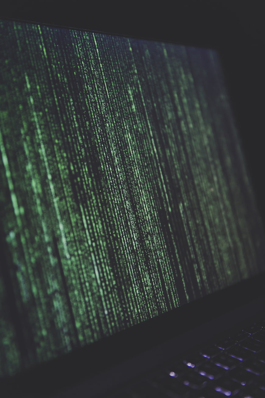 Close-up of laptop screen displaying green Matrix-style code