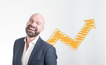 Smiling bald businessman in suit with orange growth arrow