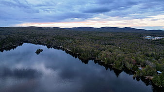 Aerial view of serene lake surrounded by forest at dusk