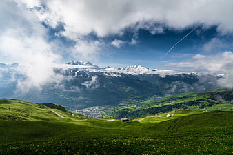 Panoramic Alpine Landscape with Green Hills and Snowy Peaks