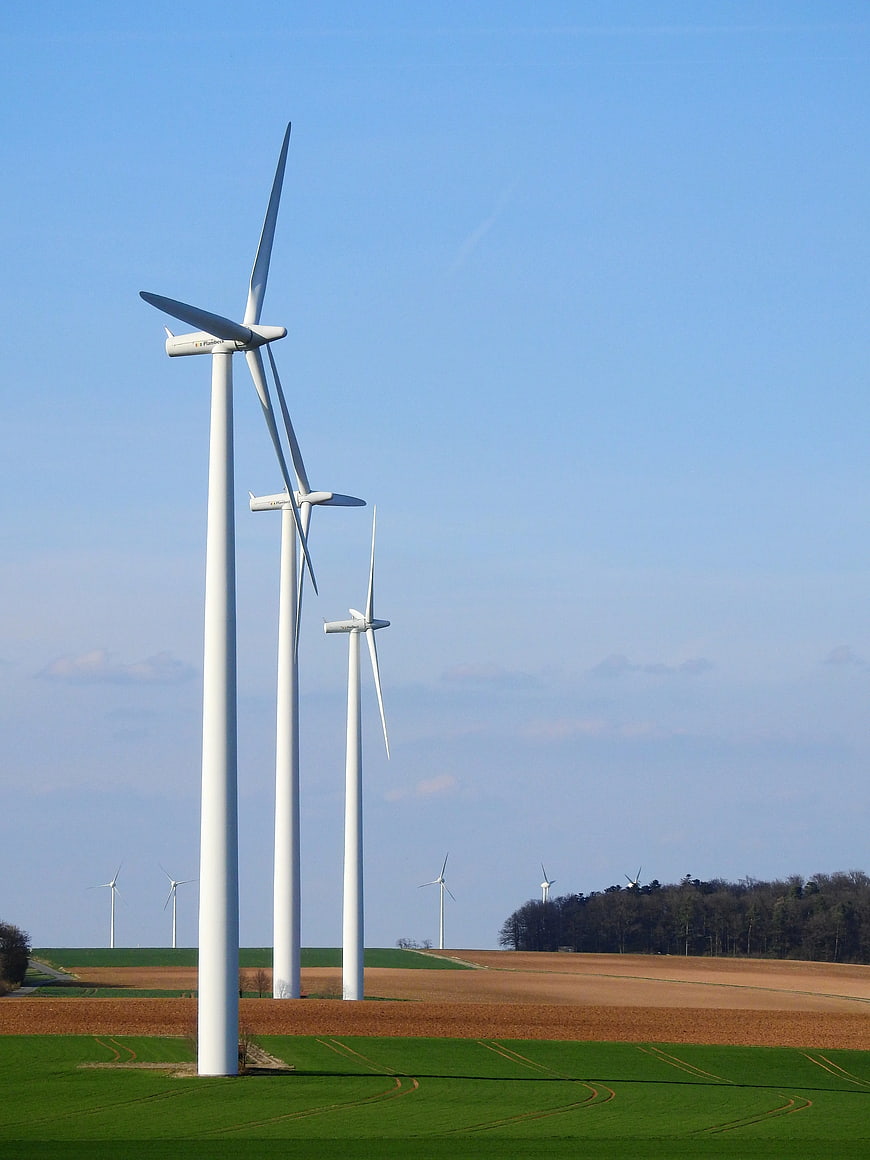 White Wind Turbines in Green and Brown Fields