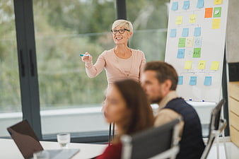 Senior Businesswoman Presenting Strategy to Team in Office