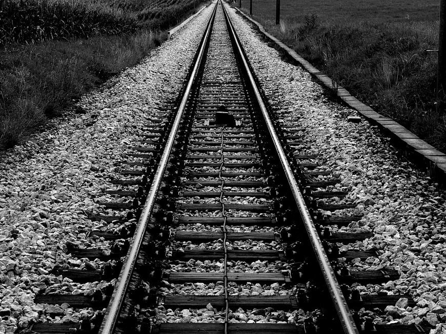 Black and white railway tracks leading into the distance