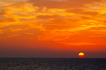 Vibrant Orange Sunset Over Calm Ocean Horizon