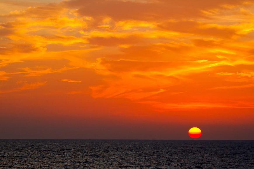 Vibrant Orange Sunset Over Calm Ocean Horizon