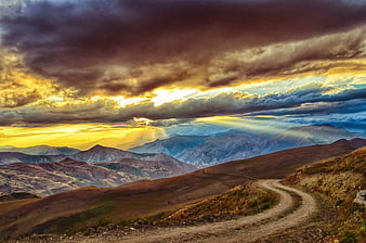 Dramatic Mountain Landscape With Winding Road And Sunset Rays