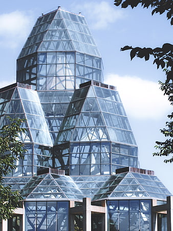Modern glass pyramid architecture against blue sky