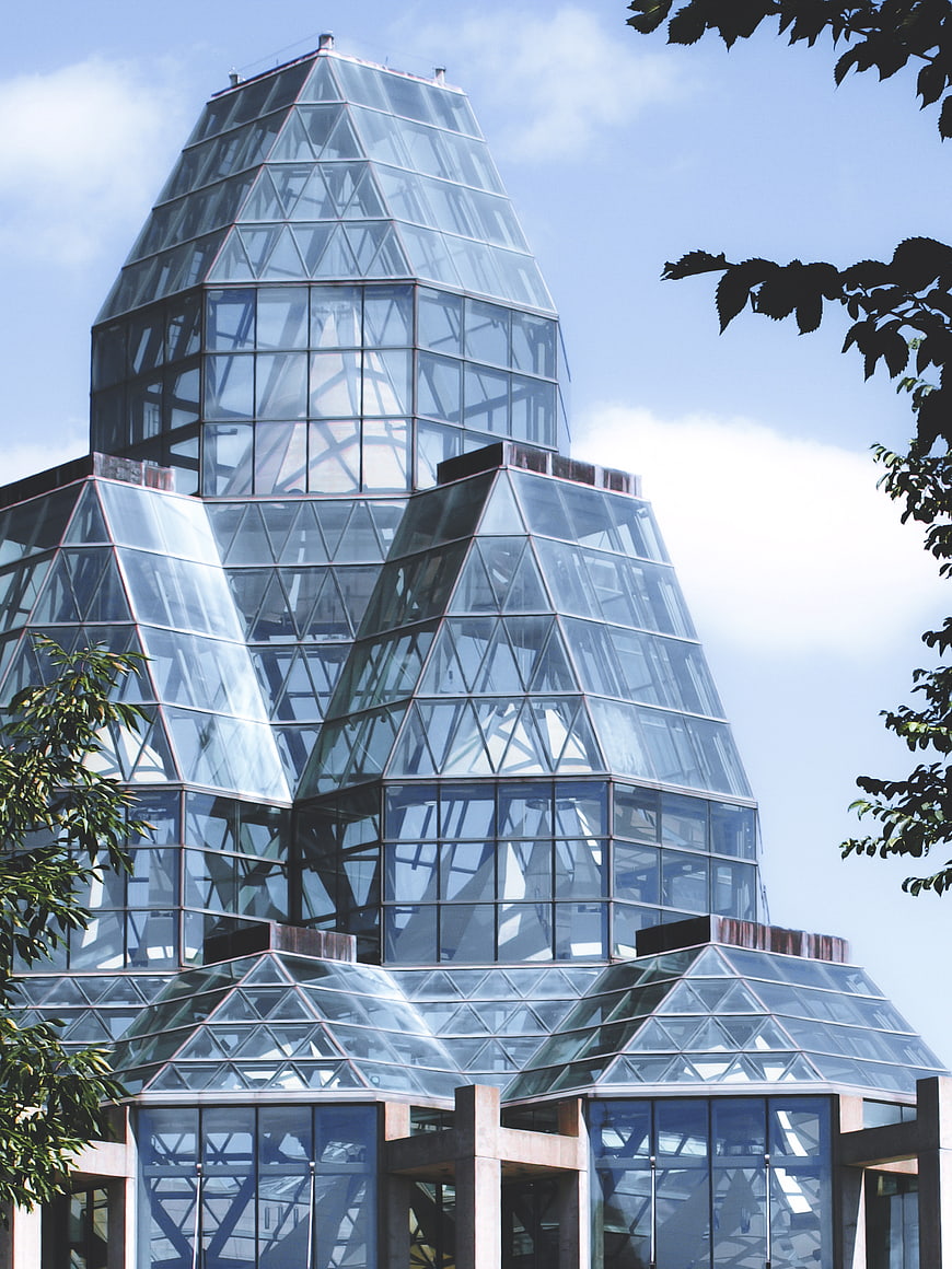 Modern glass pyramid architecture against blue sky
