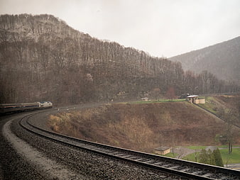 Train curving through snowy mountain landscape in winter