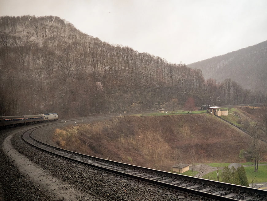 Train curving through snowy mountain landscape in winter