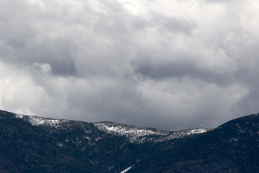 Dramatic Snow-Capped Mountains Under Stormy Clouds