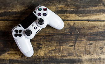 White PlayStation Controller on Rustic Wooden Background
