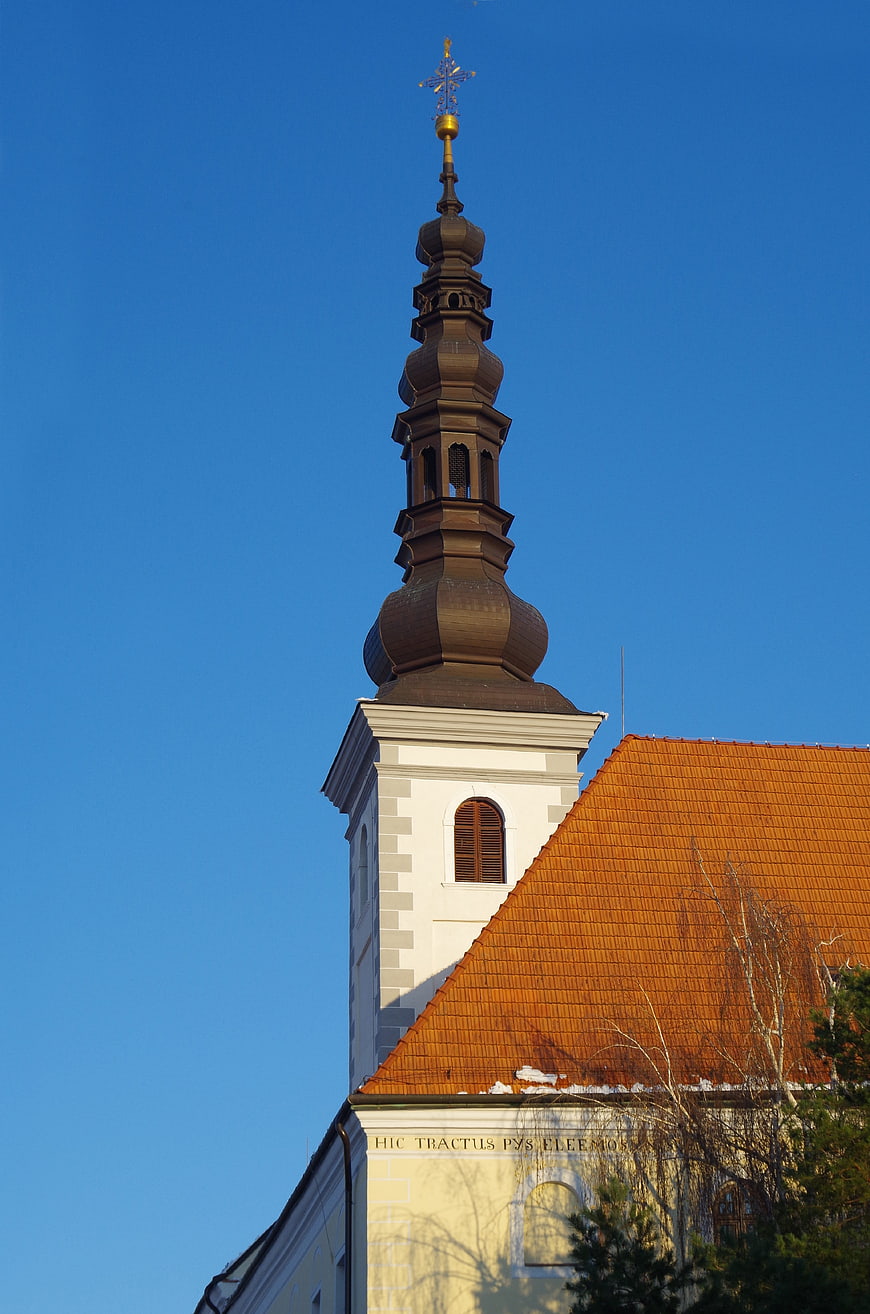 Baroque church tower with onion dome against blue sky