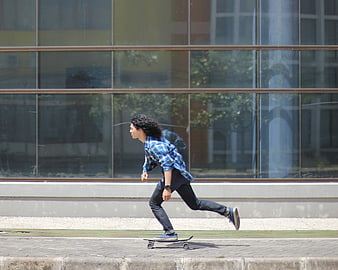 Young man skateboarding on city sidewalk