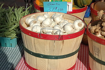 Fresh Garlic Bulbs in Wooden Bushel Basket at Farmers Market