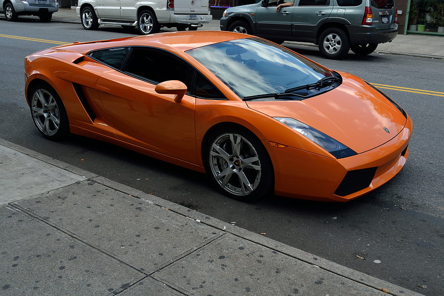 Orange Lamborghini Gallardo parked on city street