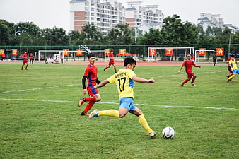 Soccer player kicking ball on green field during match